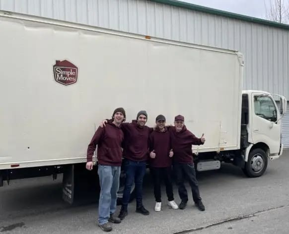 In Maple Ridge BC, four people stand in front of a Simple Moves moving truck, giving thumbs up.