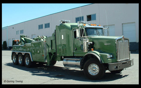 A green Kenworth tow truck is parked in Maple Ridge BC.